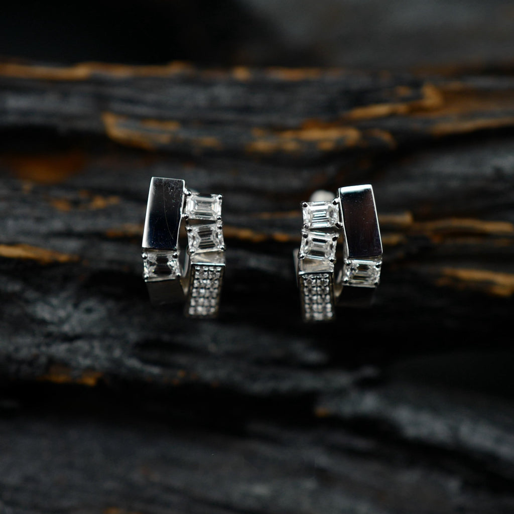 Kanpoj Verso earrings in white gold with emerald-cut diamonds, on dark wood