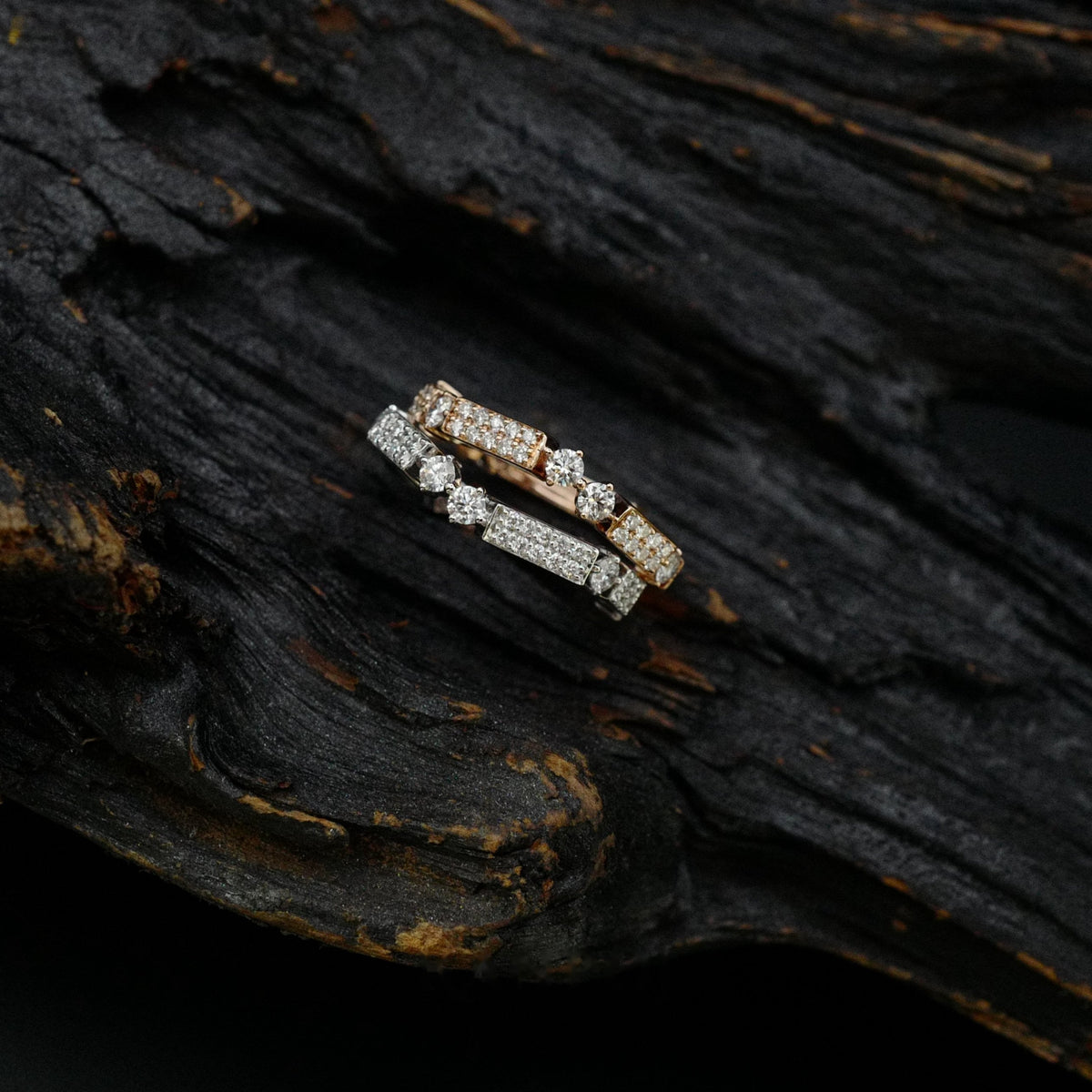 Kanpoj Verso stacked rings in pink and white gold, side view on dark wood
