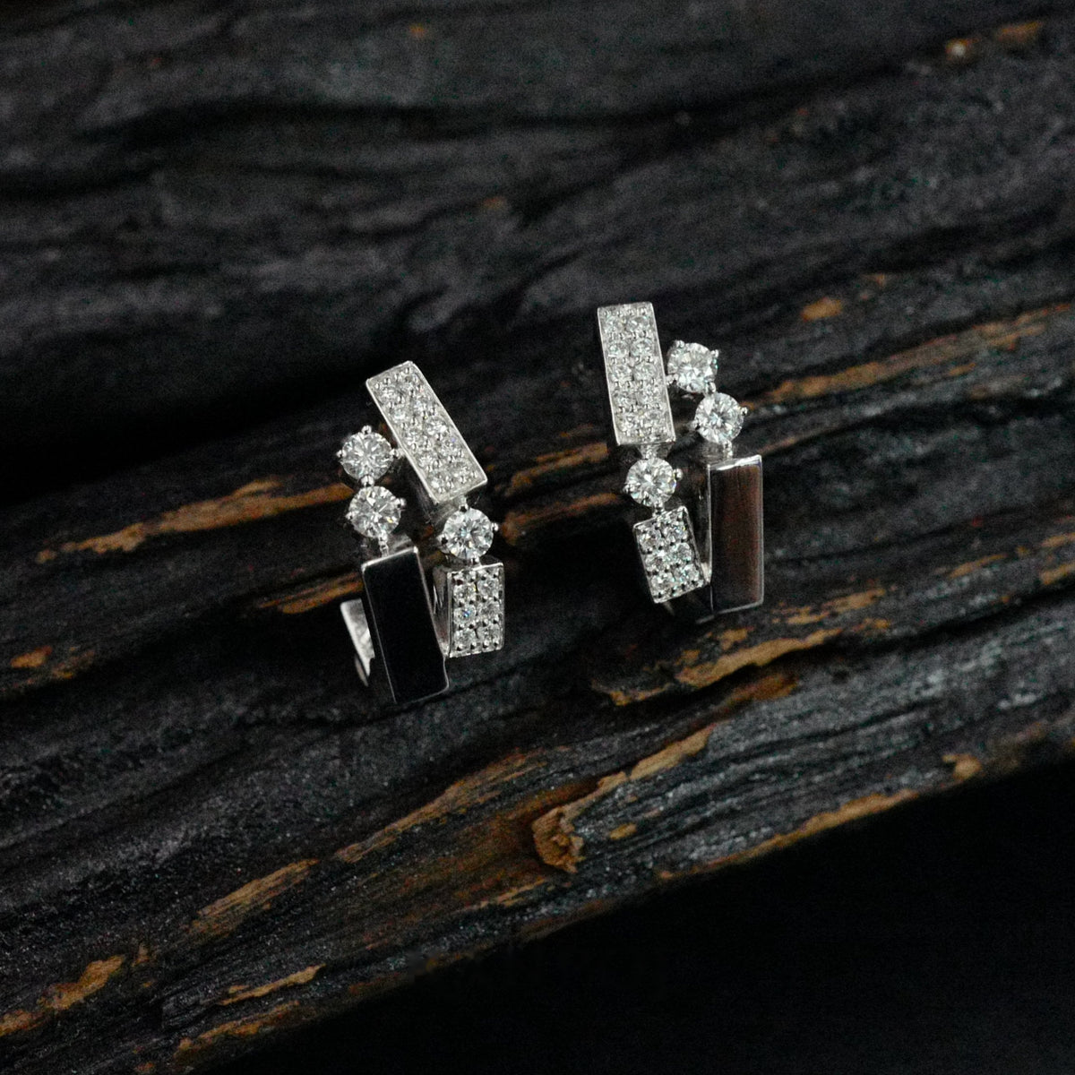 Kanpoj Verso earrings in white gold with round diamonds, on dark wood